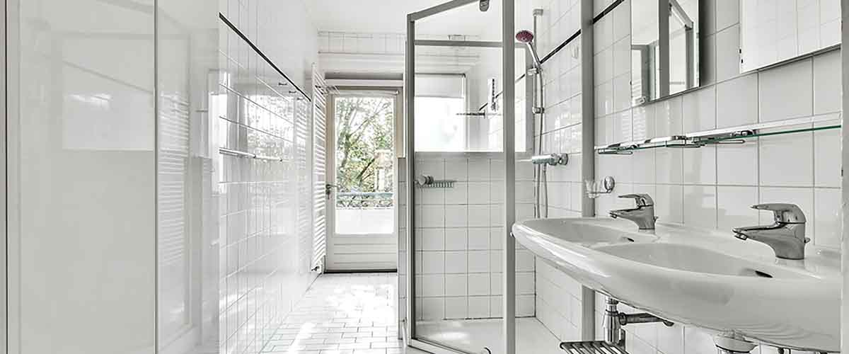 Custom frameless glass shower door installation in modern NYC bathroom by Levinson Glass