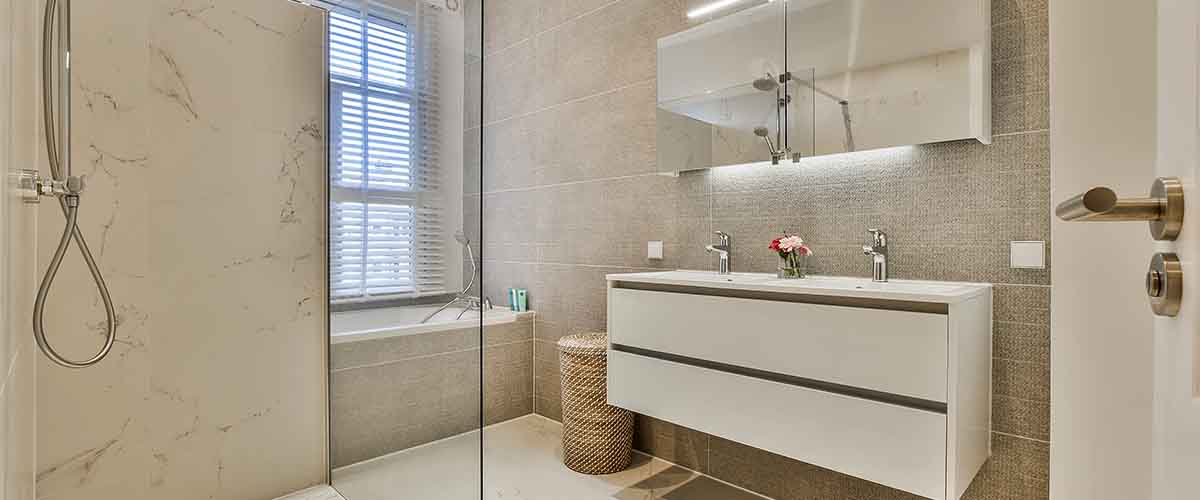 Space-saving bathroom design with custom glass enclosure in NYC